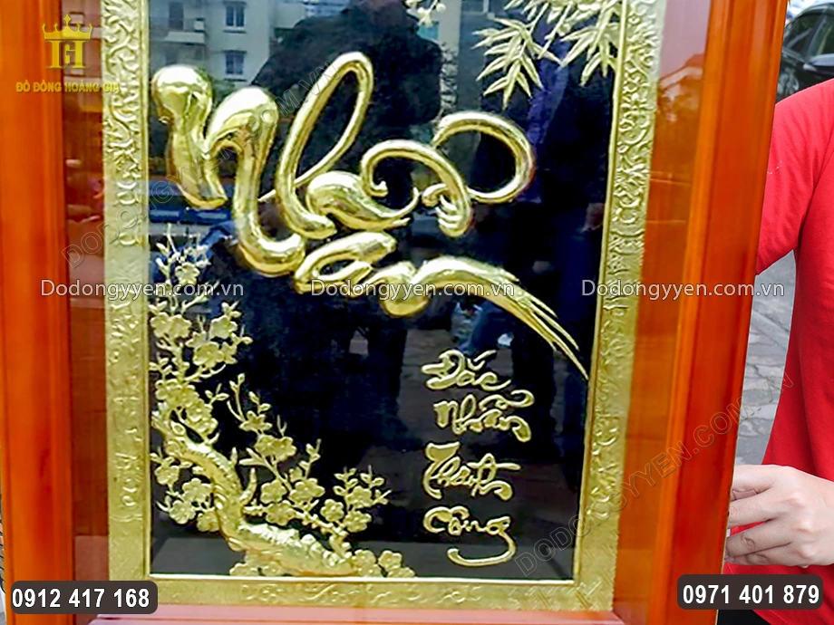 Chữ Nhẫn được chạm th&uacute;c nổi bật ở trung t&acirc;m bức tranh